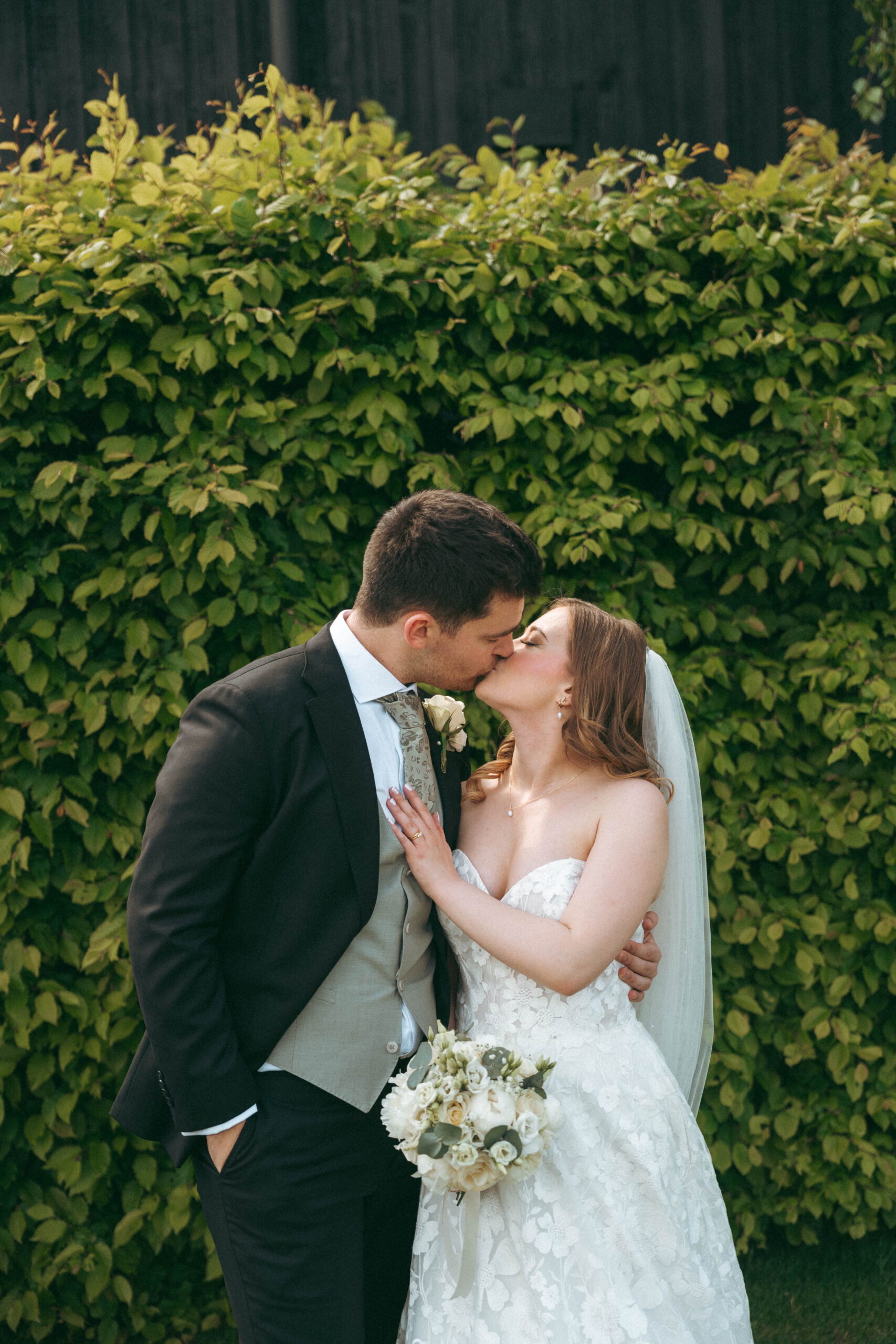 Bride and groom embracing in soft light, film wedding photography by Wychwood Weddings