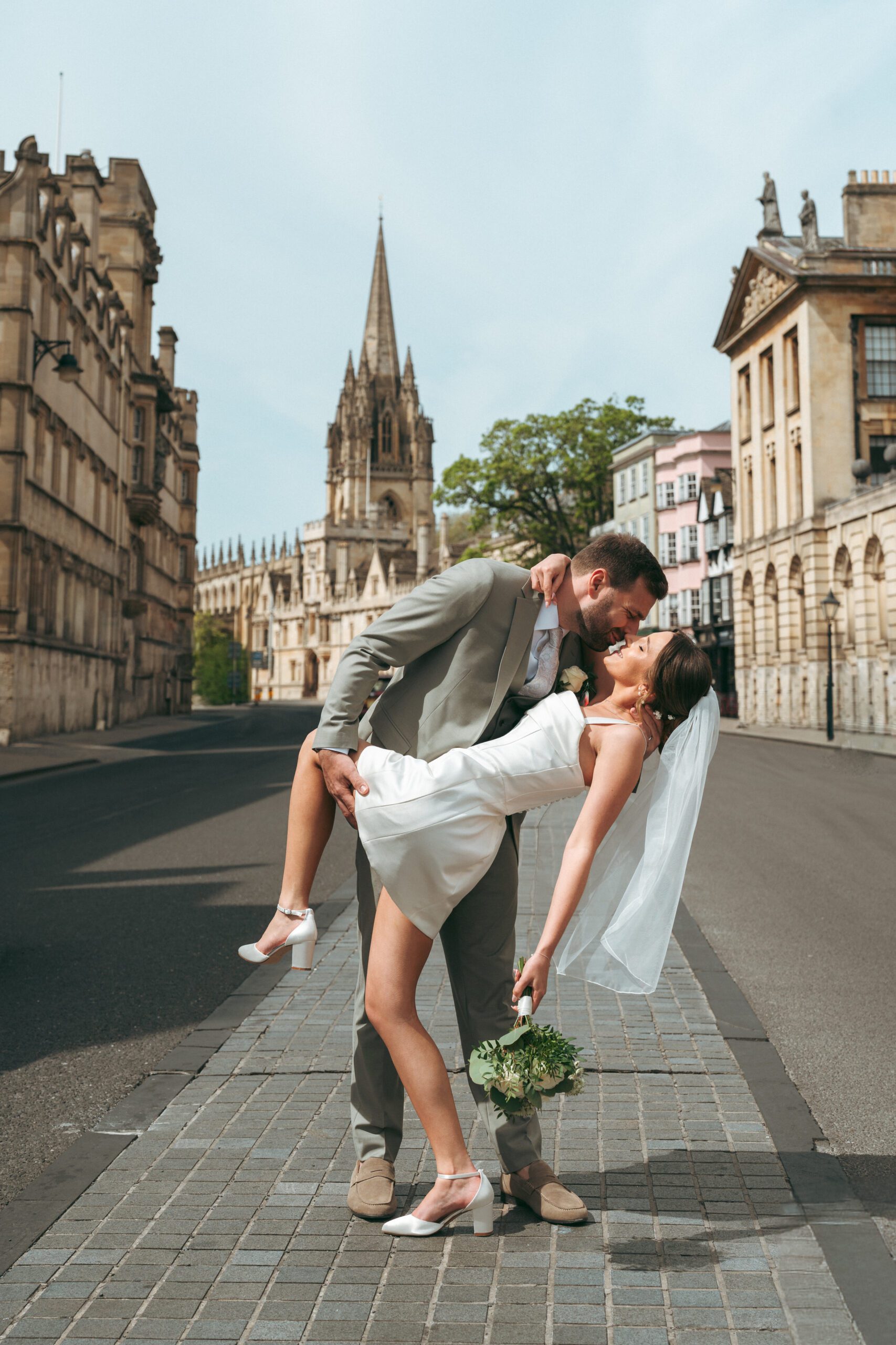 A couple pausing on a city street, candid documentary wedding photography by Wychwood Weddings
