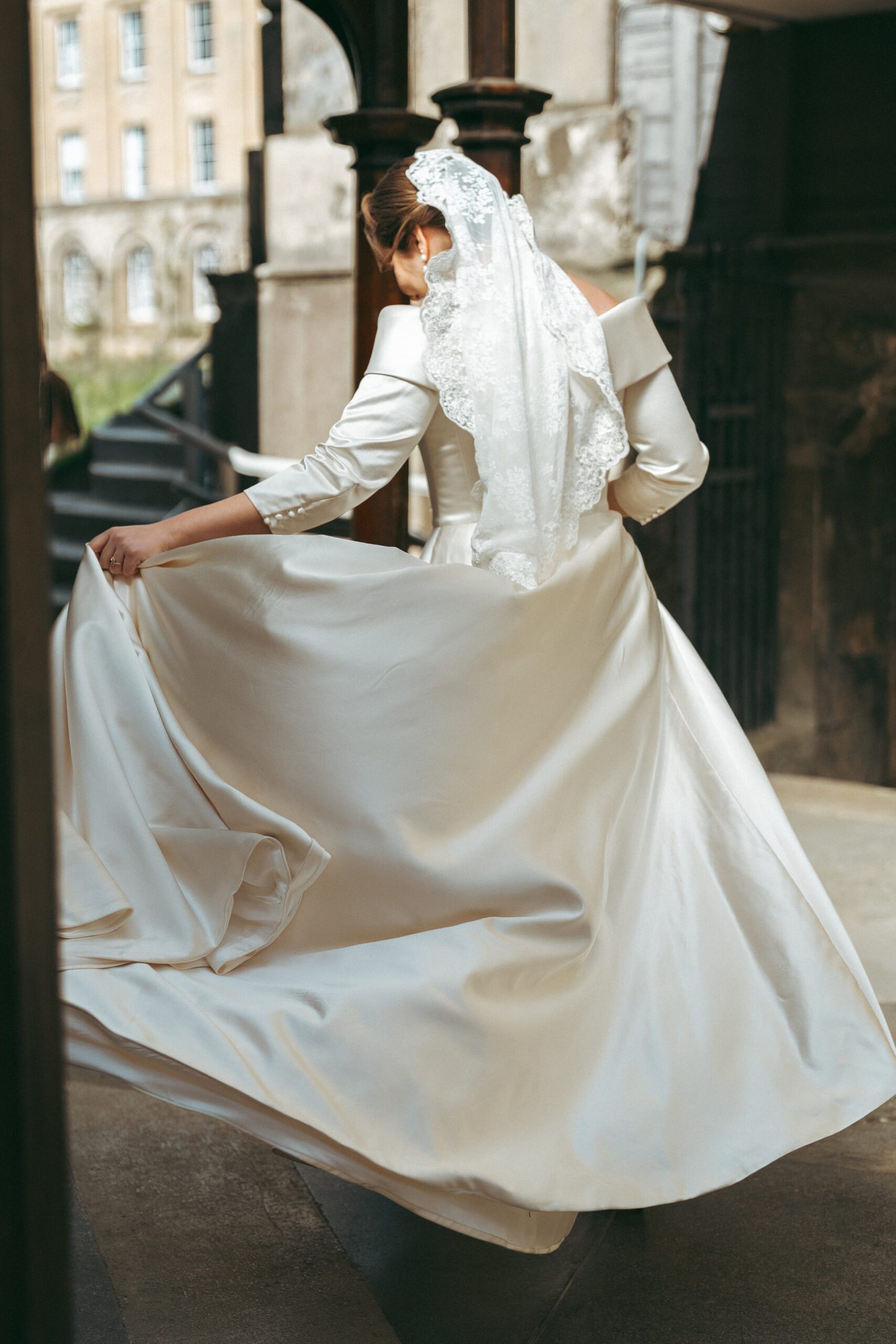 Bride portrait against a stone building, editorial wedding photography