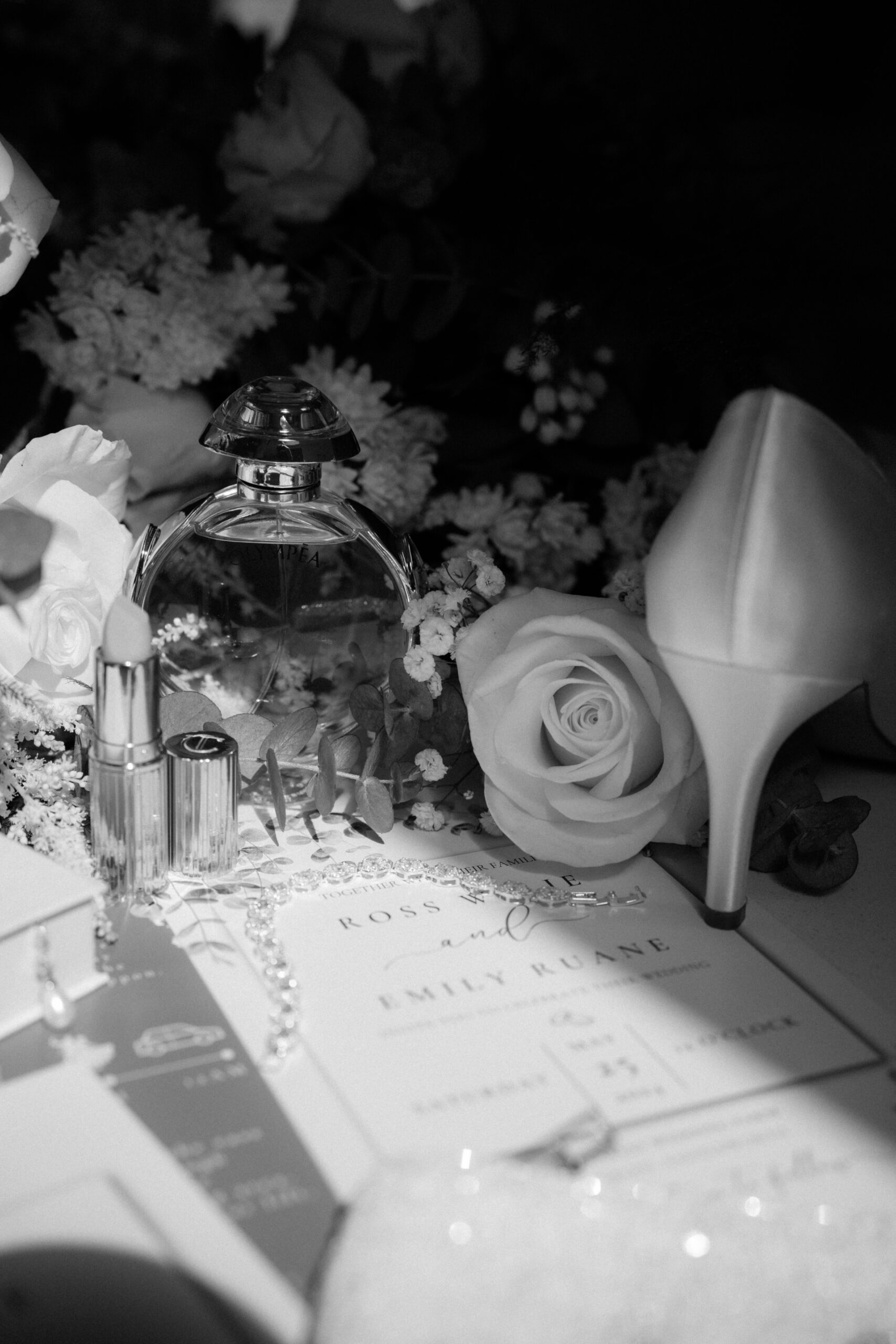 Black and white detail shot of wedding shoes and flowers