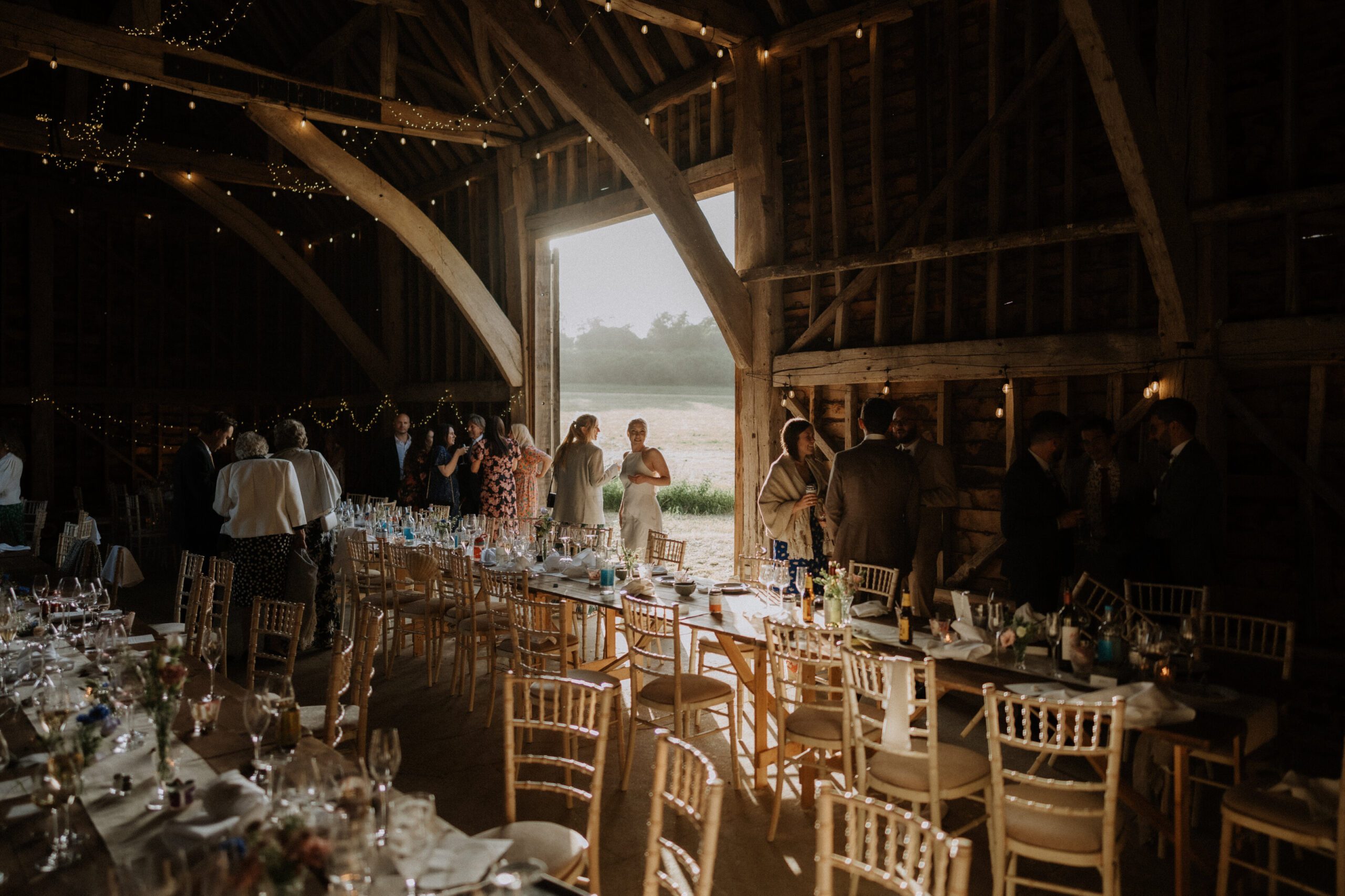 A barn wedding reception lit with fairy lights, documentary wedding photography